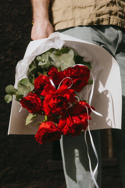 Close-up of 12 red roses with eucalyptus greenery Valentine bouquet