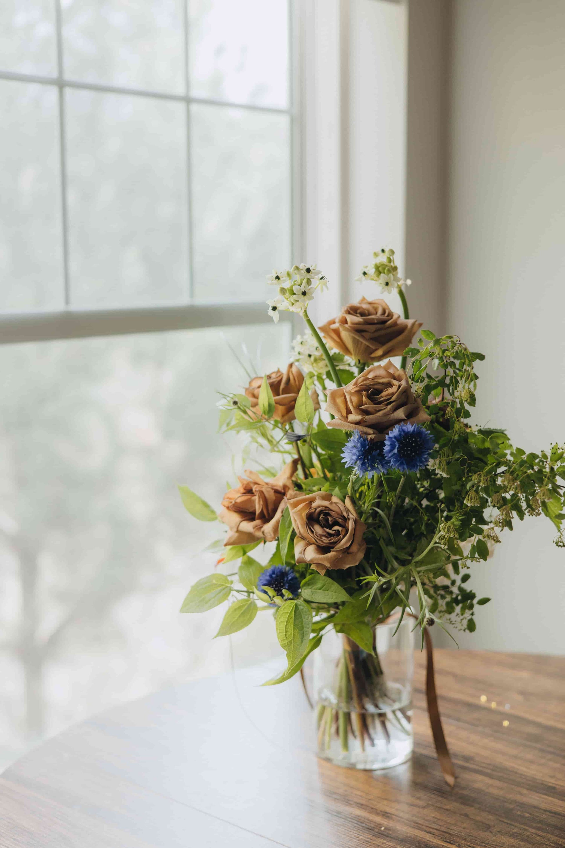 Side view of the Evening Letter bouquet with mixed greenery and soft caramel roses — Portland, OR
