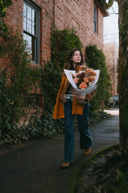 Woman carrying premium beige roses bouquet on Portland Nob Hill street