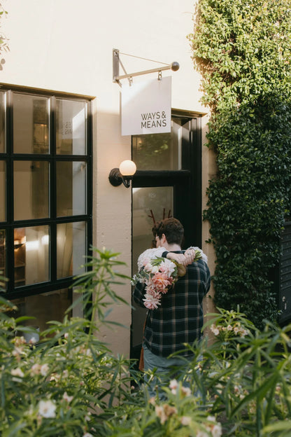 Couple embracing with pink roses bouquet at Portland cafe