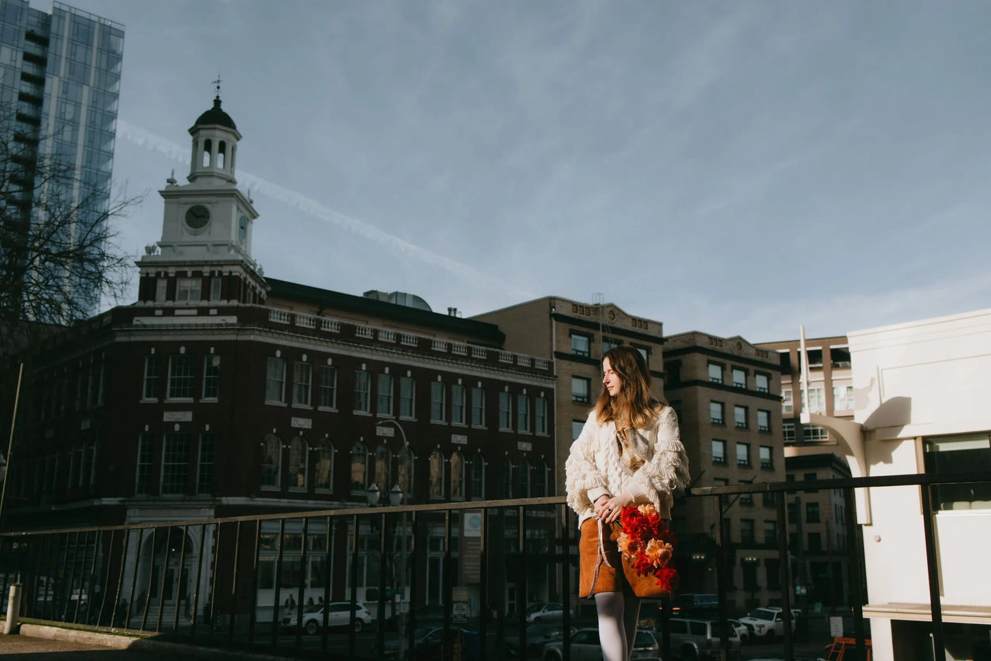 Woman with bright roses bouquet against Portland architecture
