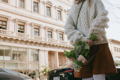 Woman with wild green bouquet against Portland architecture
