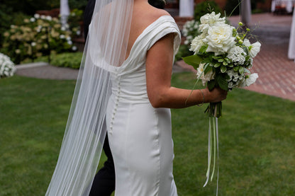 Back view of bride with white garden rose bridal bouquet and long trailing silk ribbon by Kvetka Flower Portland