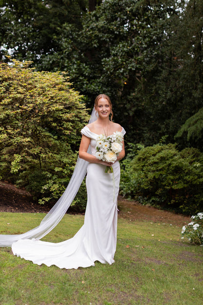 Bridal portrait holding airy white garden rose bouquet with cosmos and bear grass by Kvetka Flower Portland