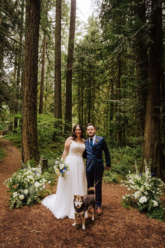 Bride smiling in the garden, holding her blue and white wedding bouquet – by Kvetka Flower, Portland OR
