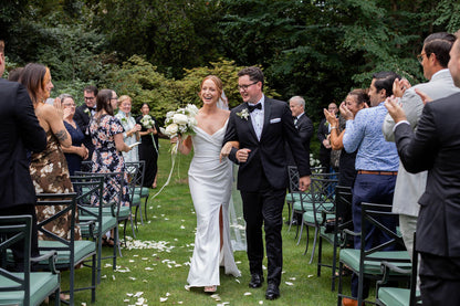Just married couple celebrating recessional with trailing white bridal bouquet by Kvetka Flower Portland