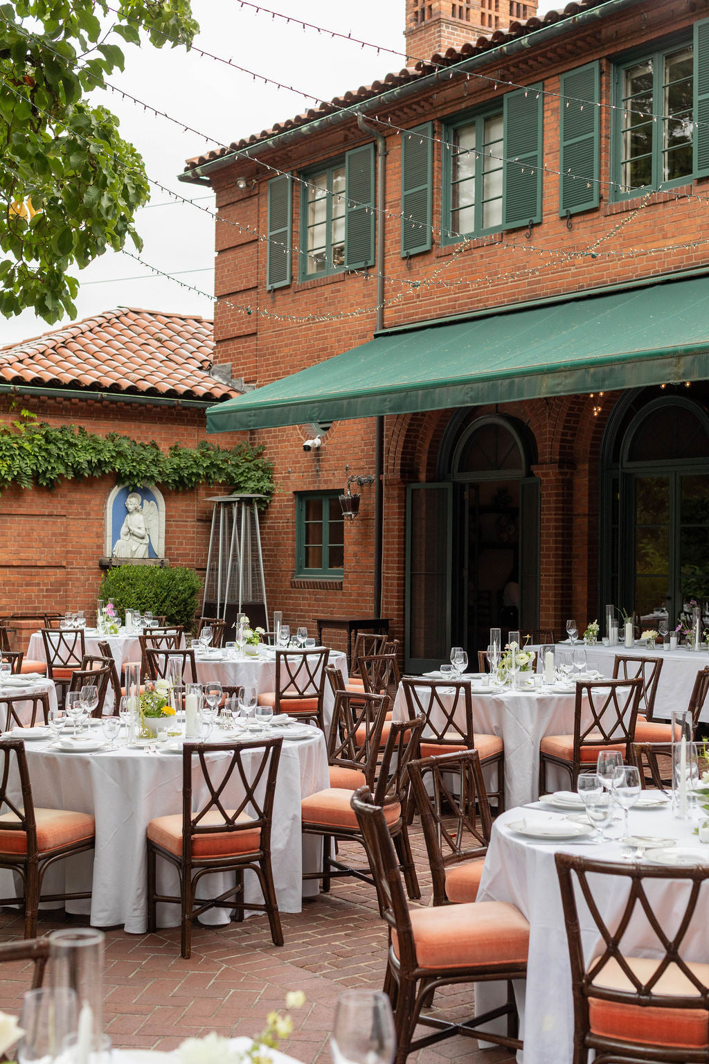 Outdoor courtyard wedding reception at The Town Club Portland with round tables and bud vase centerpieces by Kvetka Flower