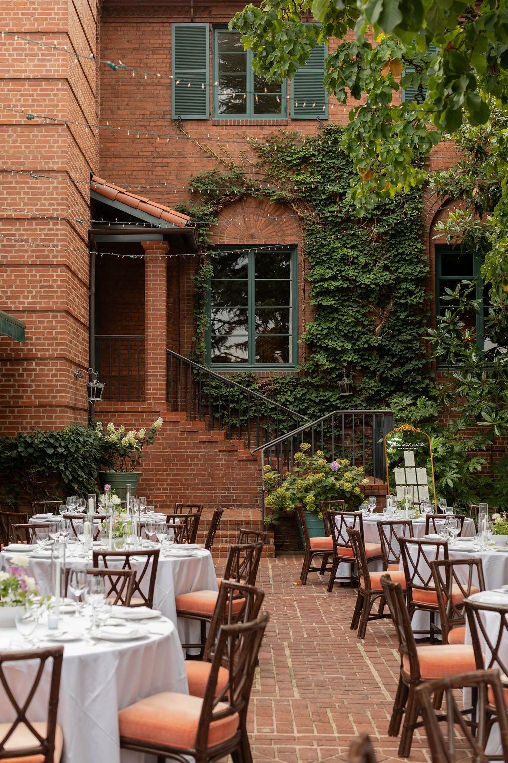 Romantic brick courtyard reception with ivy-covered staircase at The Town Club Portland, florals by Kvetka Flower