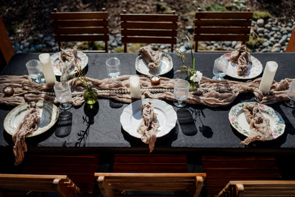 Cozy wedding tablescape with mismatched vintage plates, bud vases, black linen, and candlelight — Kvetka Flower Portland