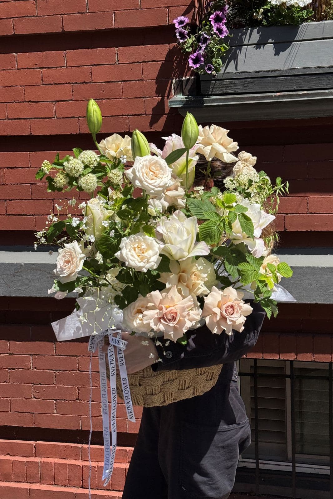 Pink Acacia flower basket with cream roses, white lilies, hydrangea, and Queen Anne's Lace by Kvetka Flower Portland