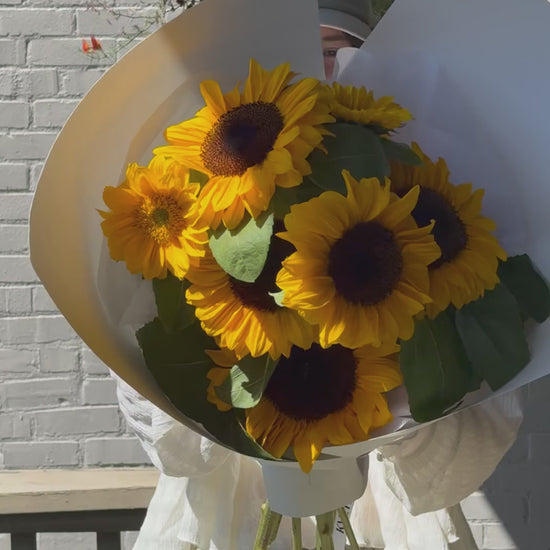 Short video showing small Sun Day sunflower bouquet being turned in hand – wrapped in paper, local flowers from Kvetka Flower Portland OR
