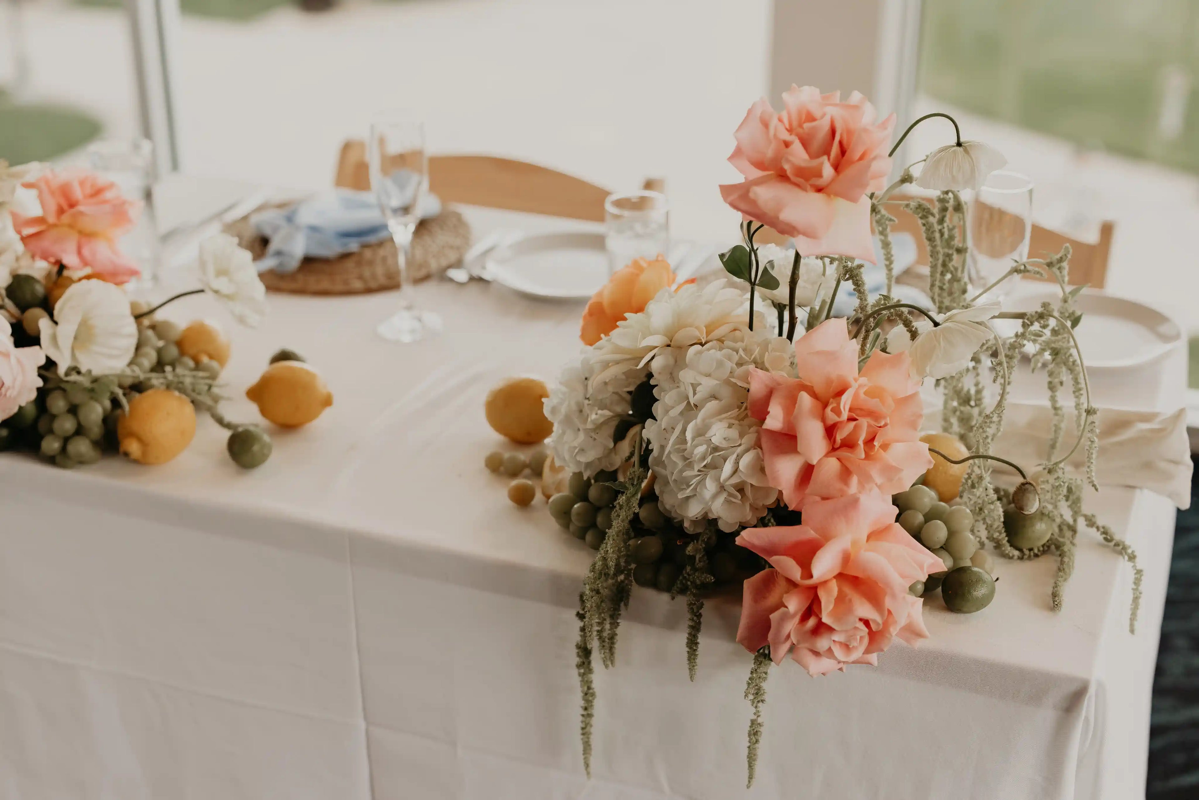 Floral decor for a wedding sweetheart table with garden roses, hydrangeas, citrus fruits and vines — designed by Kvetka Flower in Vancouver, near Portland, OR.